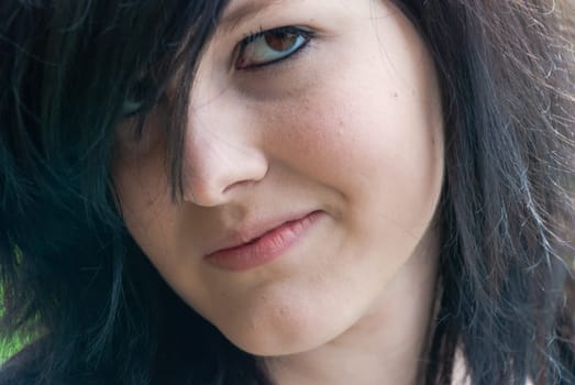 Punk emo girl, young adult with black hair and eyeliner, looking at camera, horizontal, close-up