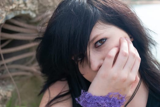 Emo punk woman smiling, looking at camera while holind her head in her right hand, horizontal