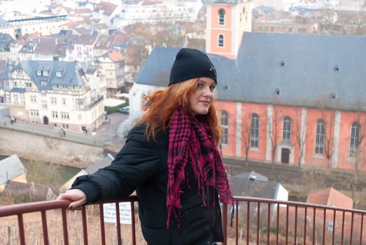 Young alternative punk emo girl looking at camera while standing on a observation point with bad kreuznach, germany in the background, horizontal