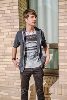 Young adult rock musician, view from the side, singer wearing a blue sweatshirt, t-shirt, standing, brown hair and beard