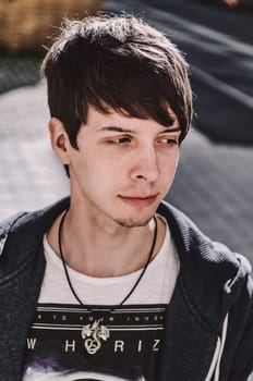 Young adult rock musician, looking away, side view, singer wearing a blue sweatshirt and t-shirt, standing, brown hair and beard