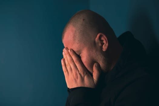 Sad man sitting in dark room. Depression and anxiety concept