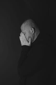 Sad man sitting in dark room. Depression and anxiety concept