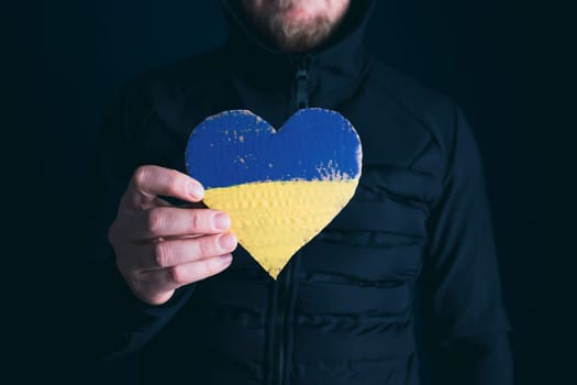 Heart shaped flag of Ukraine in female hands. The concept of solidarity with the citizens of Ukraine.