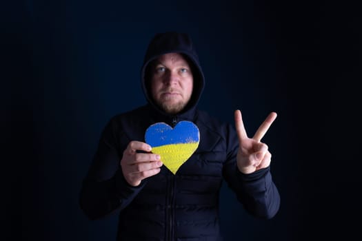 Heart shaped flag of Ukraine in female hands. The concept of solidarity with the citizens of Ukraine.