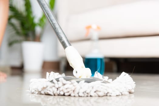 Asian woman washes the floor with a mop and rag indoors, housewife washing floor mopping at home in living room cleaning her home, Professional housekeeping job house cleanup concept