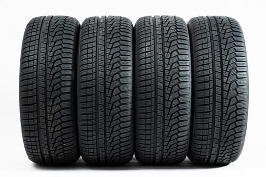 Four wheels with winter tires from front view isolated on white background. Complete set of new rubber car parts cut out on blank. Concept of safe travels.