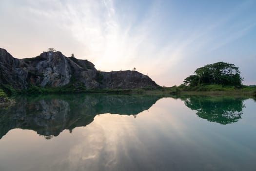 Beautiful reflection of dramatic sunset at abandoned quarry