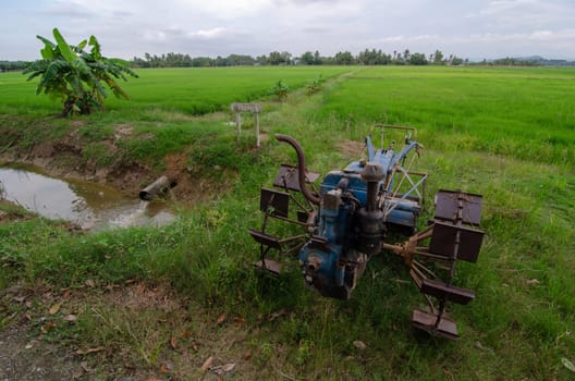 Walking tractor used to plowing park at paddy field.