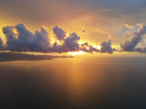Dramatic orange color sky during sunset hour at sea. Aerial view.
