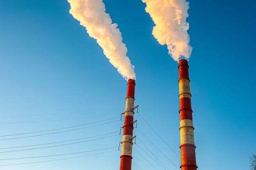 white smoke is coming out of the pipes in the blue sky. High quality photo