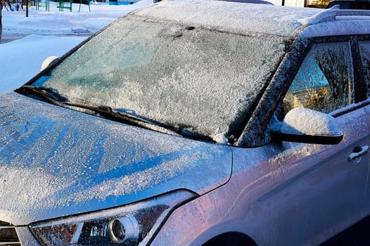 The windshield covered with frost at the car on a sun winter day. High quality photo
