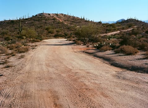 Dirt road leading off into the desert mountains