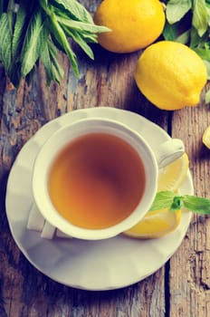 Cup of tea with lemon slices. Retro filter.