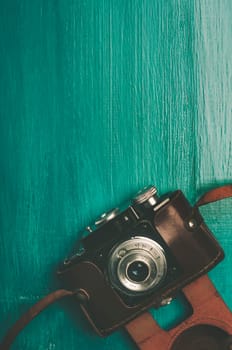 Vintage photo camera on rustic blue background