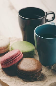 Two cup of coffee and colorful macaroons. Retro filter.
