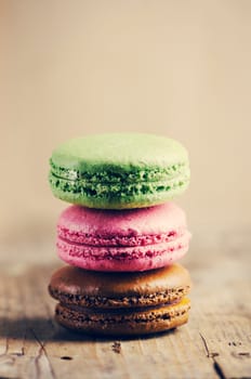 Colorful macaroons on wooden table. Retro filter.