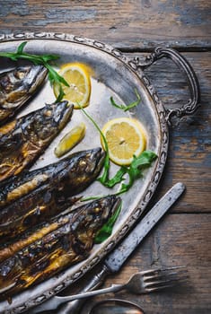 Mackerels seved on silver plate with lemon