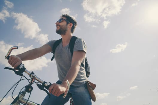 Man riding a bicycle in nature in retro style.