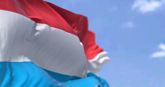 Detail of the national flag of Luxembourg waving in the wind on a clear day. Luxembourg is a landlocked country in Western Europe. Selective focus.