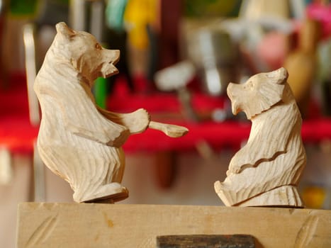 she bear feeds her cub, carved wooden toy