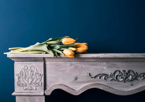 Tulip bouquet on vintage fireplace and blue wall