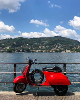 Red Vespa parked by Lake Como