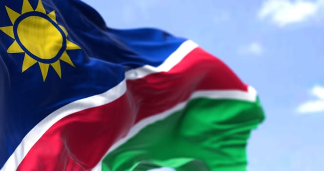 Detail of the national flag of Namibia waving in the wind on a clear day. Namibia is a country in Southern Africa. Selective focus.