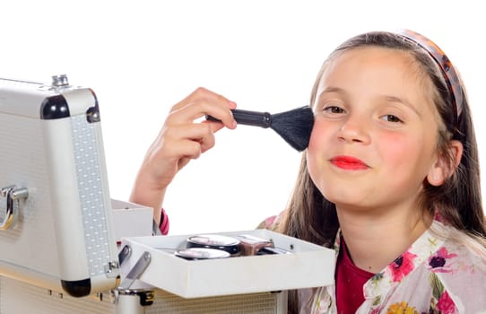 a little girl puts makeup of his mother