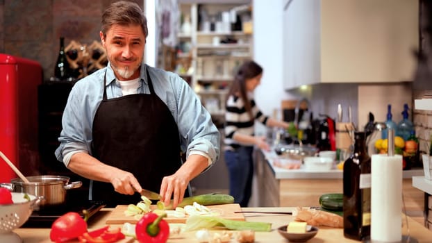 Caucasian man cooking in the kitchen at home. Mature age, middle age, mid adult white man in 50s.