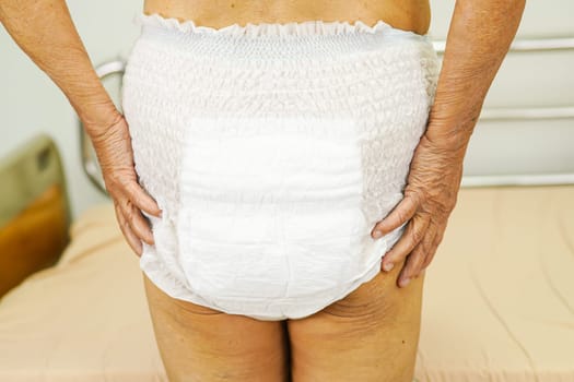 Asian elder senior woman patient wearing adult incontinence diaper pad in hospital.