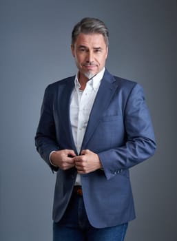 Business portrait of older businessman against gray background.