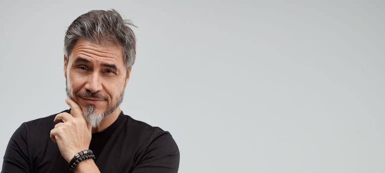 Portrait of happy older white man, beard gray hair, smiling. Gray background, wide banner, copy space.