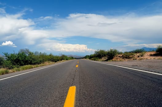 Paved road going off into the desert mountains