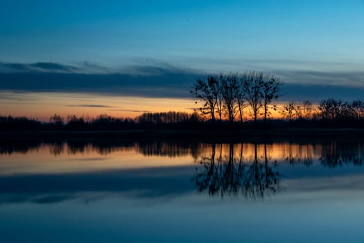 Reflection of trees in the water after sunset, Stankow, Poland