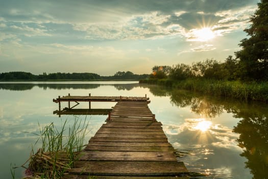Sunlight reflecting on the lake with a pier, Stankow, Poland