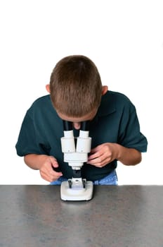 Young boy scientist with microscope examining a sample