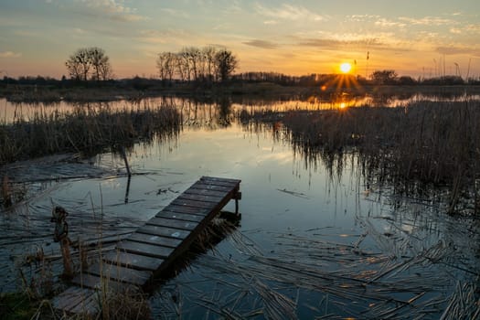 A small pier and a lake with reeds, evening sunset, Stankow, Lubelskie, Poland