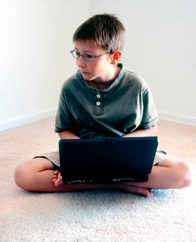 School from home A Young boy intently studying his laptop