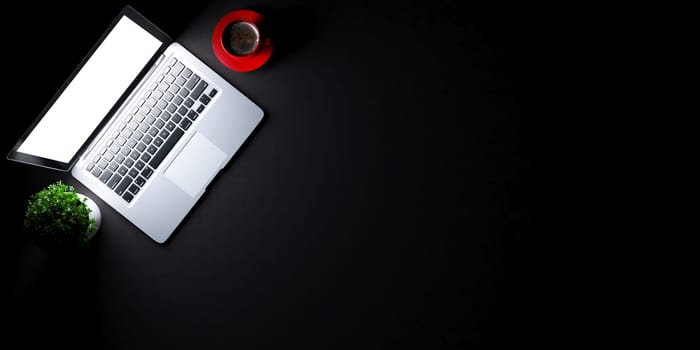 Top view of laptop concept with black desk under spot light and red coffee cup concept background 3D rendering