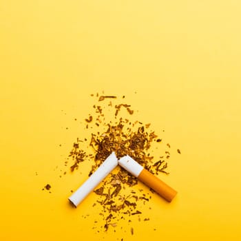 31 May of World No Tobacco Day, no smoking, close up of broken pile cigarette or tobacco STOP symbolic on yellow background with copy space, and Warning lung health concept