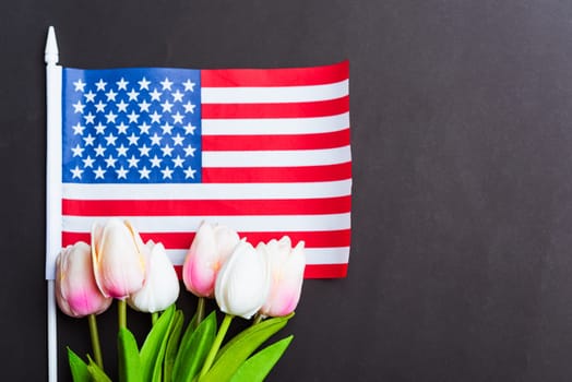 Happy Memorial Day Remember previously but now seldom called Decoration Day, American flag and a Tulip flower on a black background and copy space, a federal holiday in the United States