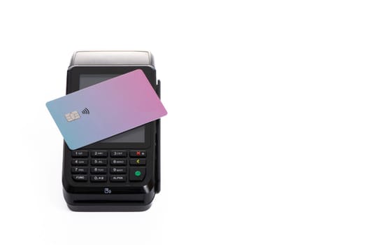 the plastic card lies on the payment terminal with a white isolated background. High quality photo