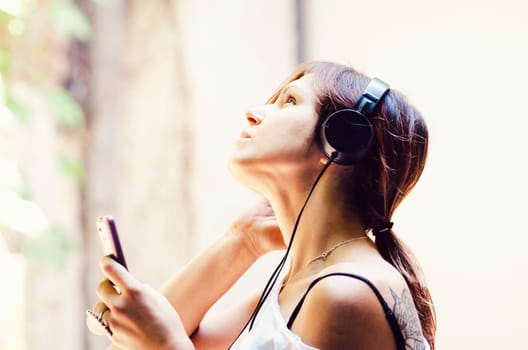Young girl listening the music in the street.