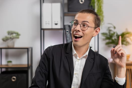 Smiling young Caucasian man freelancer thinking finding a good idea. Professional businessman writing important email from home at table. Happy guy working online remote distance job