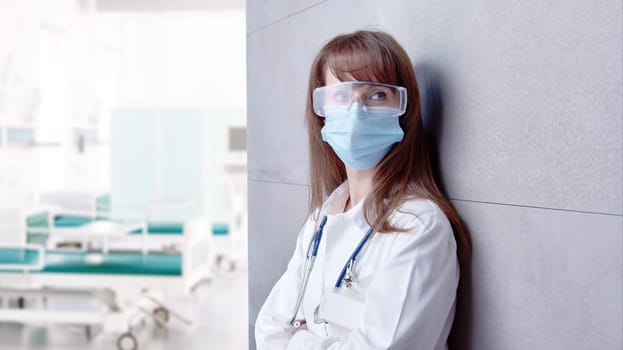 Covid-19 - Smiling female doctor in glasses on hospital corridor, Confident young woman.