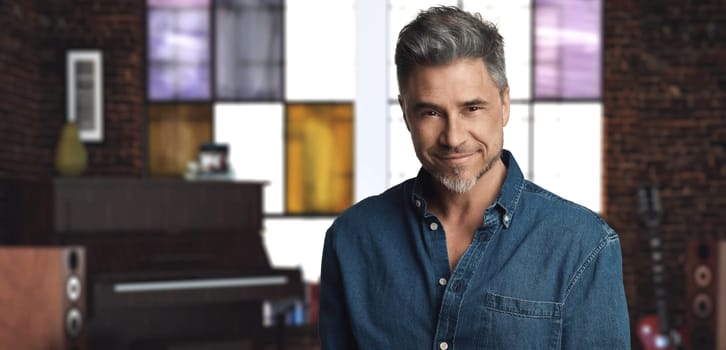 Portrait of casual older man - musician at home smiling.