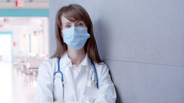 Covid-19 - Smiling female doctor in glasses on hospital corridor, Confident young woman.