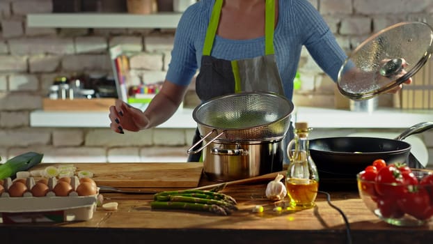 Woman cooking in kitchen. Real people, authentic, no face.