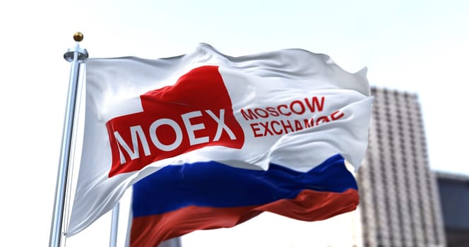 Moscow, RUS, March 2022: the flag of the Moscow Exchange waving in the wind with the Russian national flag blurred in the background. The Moscow Stock Exchange is the largest stock exchange in Russia